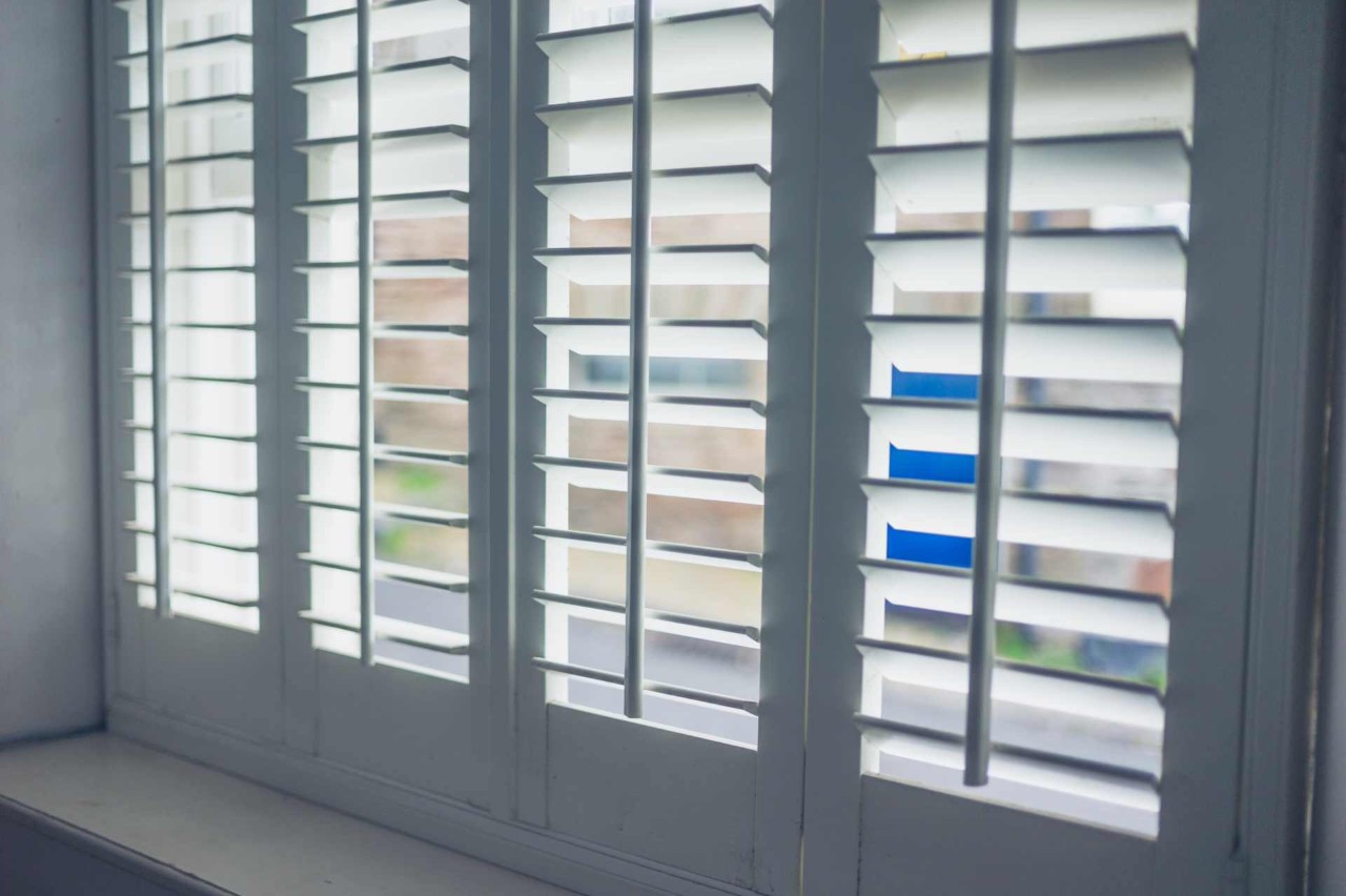 Hunter Douglas Heritance® Hardwood Shutters hanging gracefully in a suburban home