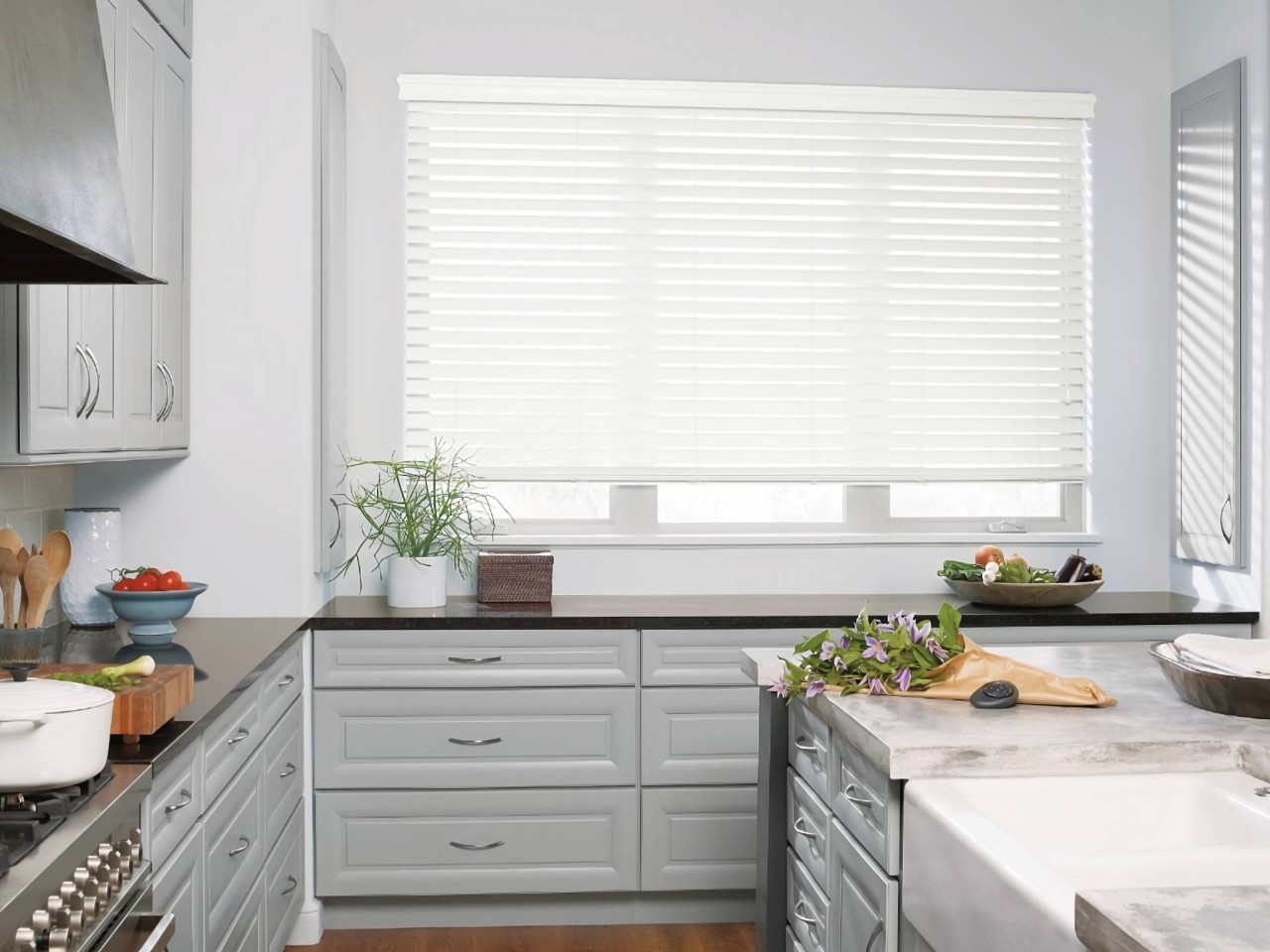 A modern kitchen with Hunter Douglas EverWood® Faux Wood Blinds on a large window at Dale's AAA Blind Factory near Naples, FL