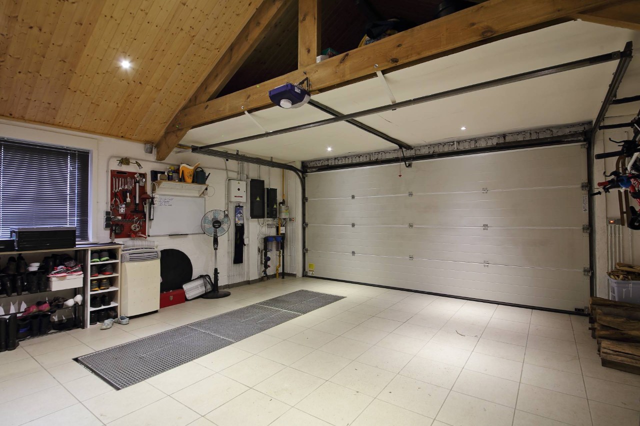Large, modern, and tidy garage with shelves on the side below a window with metal blinds at Dale's AAA Blind Factory near Naples, FL