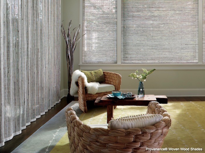 A living room with woven wood shades and a silky rug.